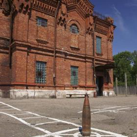 1. Liepājas Karostas garnizona cietums celts 20.gadsimta sākumā - ap 1904.gadu - Karostas hospitāļa vajadzībām, tomēr kā hospitālis nekad nav izmantots. Vēstures pētnieks Juris Raķis, kurš Karostas cietumā strādā par gidu, stāsta, ka sarkano ķieģeļu, kas izgatavoti tepat Liepājas apriņķī, ēkai ir divi stāvi. Pagraba tai nav: "Nevienā Karostas mājā nav pagraba. Kad tika būvēta Karosta, zemes bija pietiekami, lai nebūtu jāierokas pazemē. Vietas bija gan šķūnīšiem, gan noliktavām. Arī bēniņi ir tīri funkcionāli. Tajos atrodas gaisa cirkulācijas regulācijas iekārtas un bija vieta ūdens rezervuāriem.